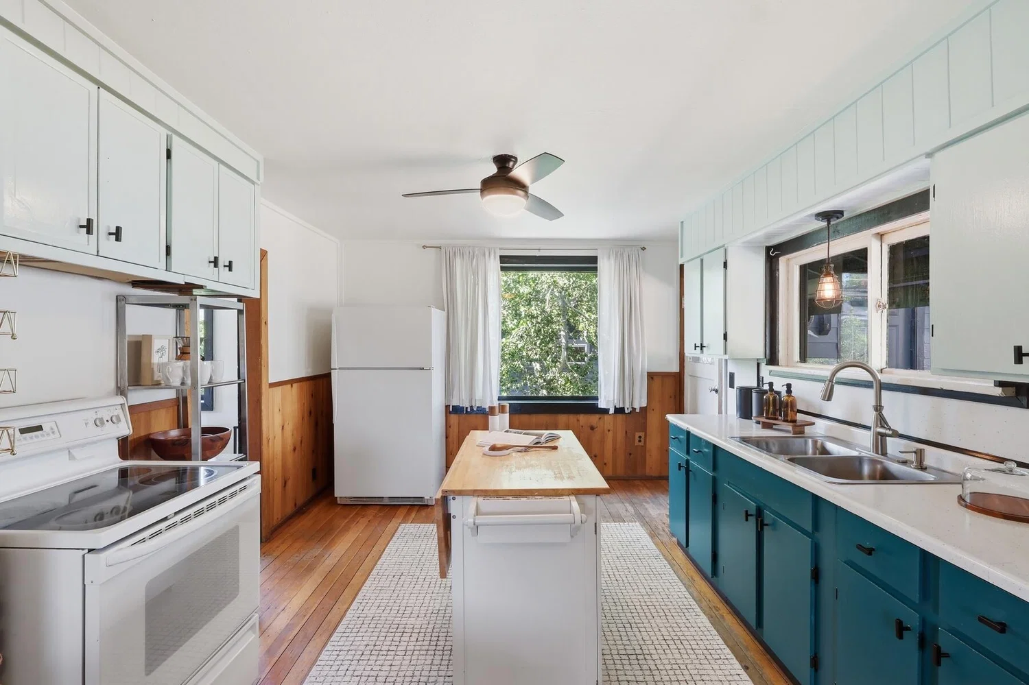 Kitchen with teal lower cabinets and hardwood floors