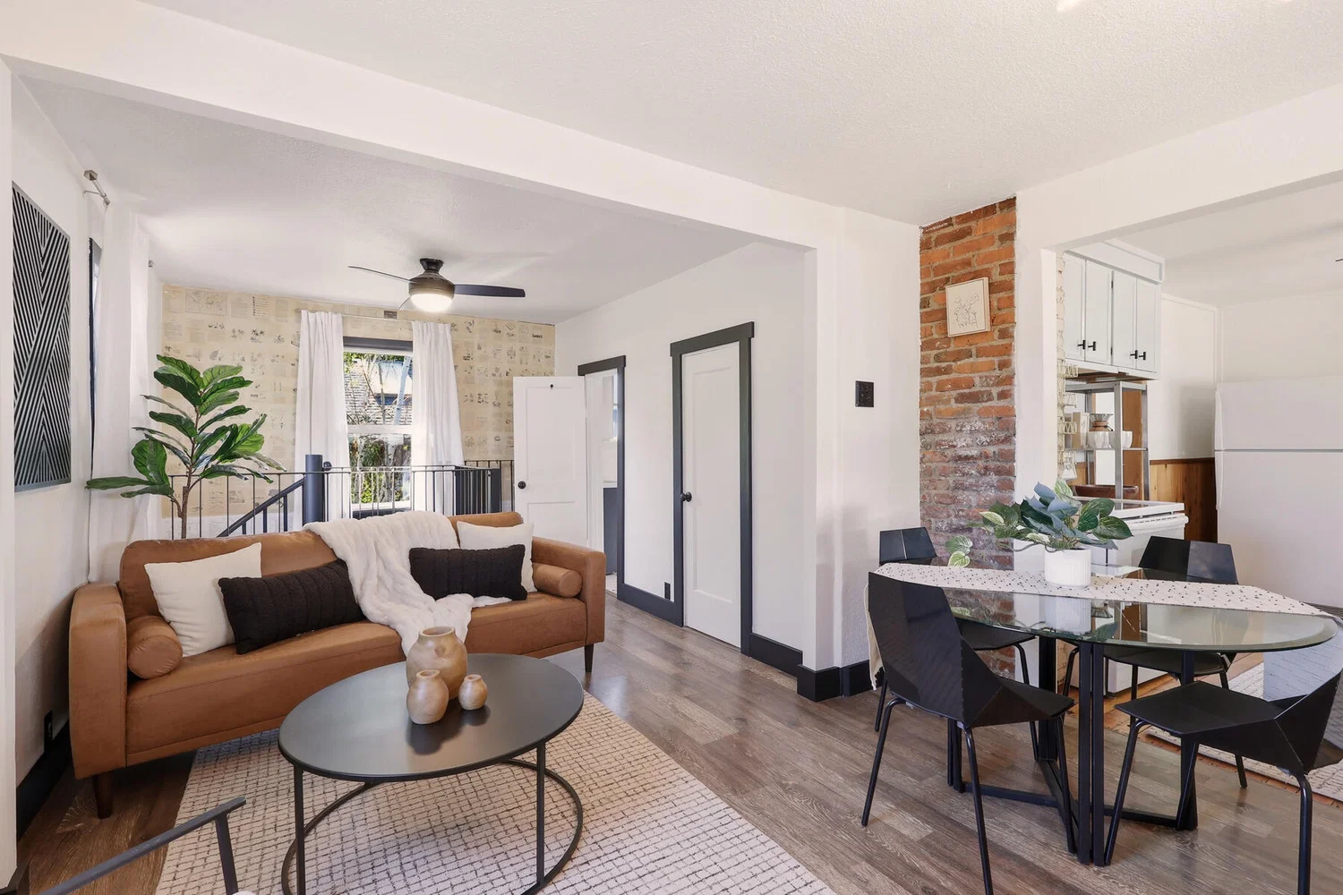 Living room with exposed brick accent and hardwood floors